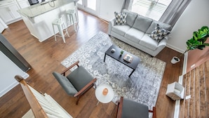A modern living room with a grey sofa, two armchairs, a coffee table, and a patterned rug. - 1 King 3 Queens Ground Room Washer Dryer (Old Hickory)