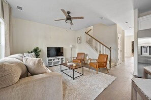 A living room with a sofa, coffee table, chairs, a TV, a ceiling fan, and a staircase. - 1 King 2 Queens Garage Yard Washer Dryer (Old Hickory)