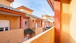 Un estrecho callejón entre edificios con tejados de tejas y balcones.