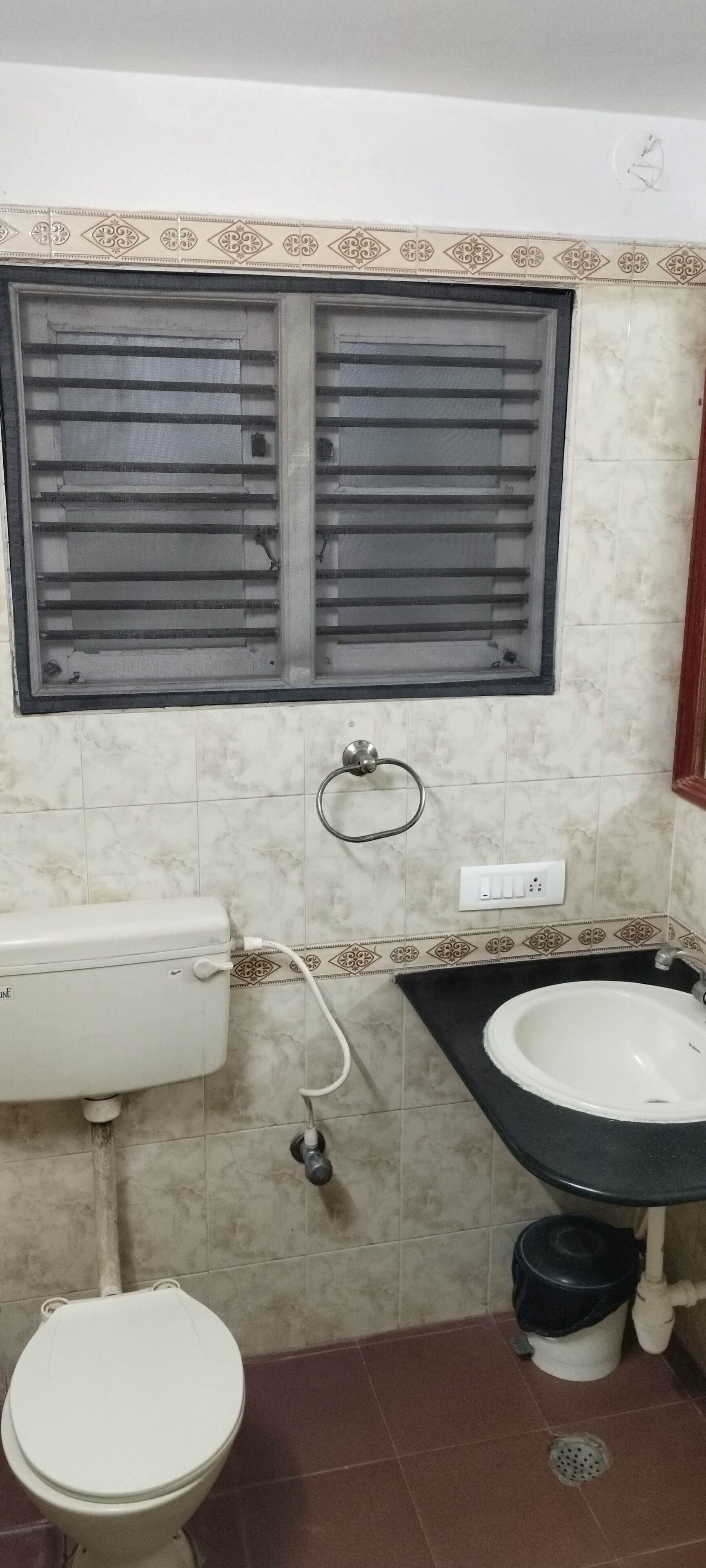 A bathroom with a toilet, sink, and window with blinds.
