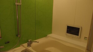 Un baño con bañera, ducha y panel de control en la pared.