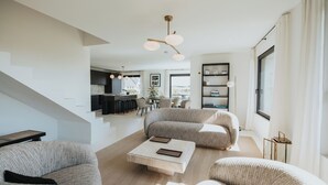 A modern living room with a sofa, coffee table, and a staircase leading to an upper level. - Exceptional villa with ocean views—comfort and charm, Brittany (Lanildut)