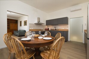 A modern kitchen with dark cabinets, a built-in oven, and a stainless steel range hood. - Serristori Riverside Apartment (Florence)