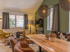 Uma sala de estar moderna com uma mesa de jantar de madeira, cadeiras de couro e um sofá.