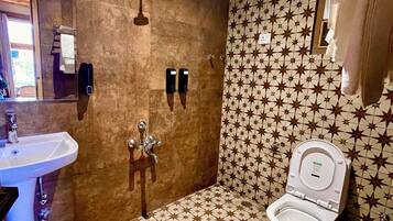 A bathroom with a star-patterned floor, a sink, a shower, and a toilet.
