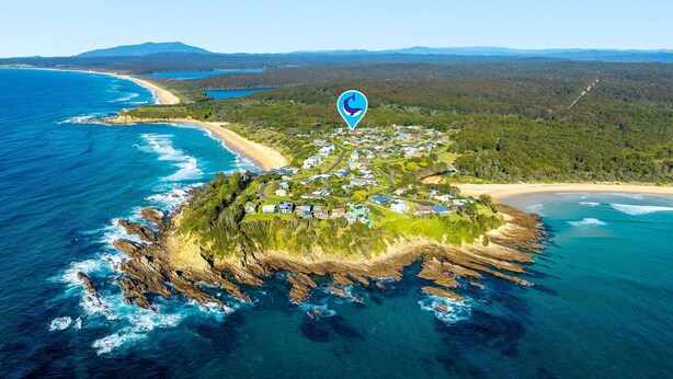 An aerial view of a coastal town with a beach, surrounded by forested hills. - 12 Borang @ The Point (Potato Point)