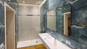Une salle de bain moderne avec une douche à parois de verre, un lavabo blanc et un grand miroir.