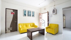Una habitación con un sofá amarillo, un sillón a juego y una mesa de centro de madera.