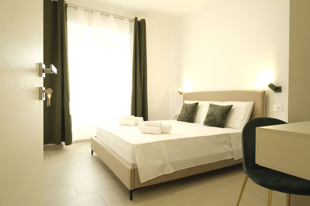 A hotel room with a bed, a desk, and a chair.