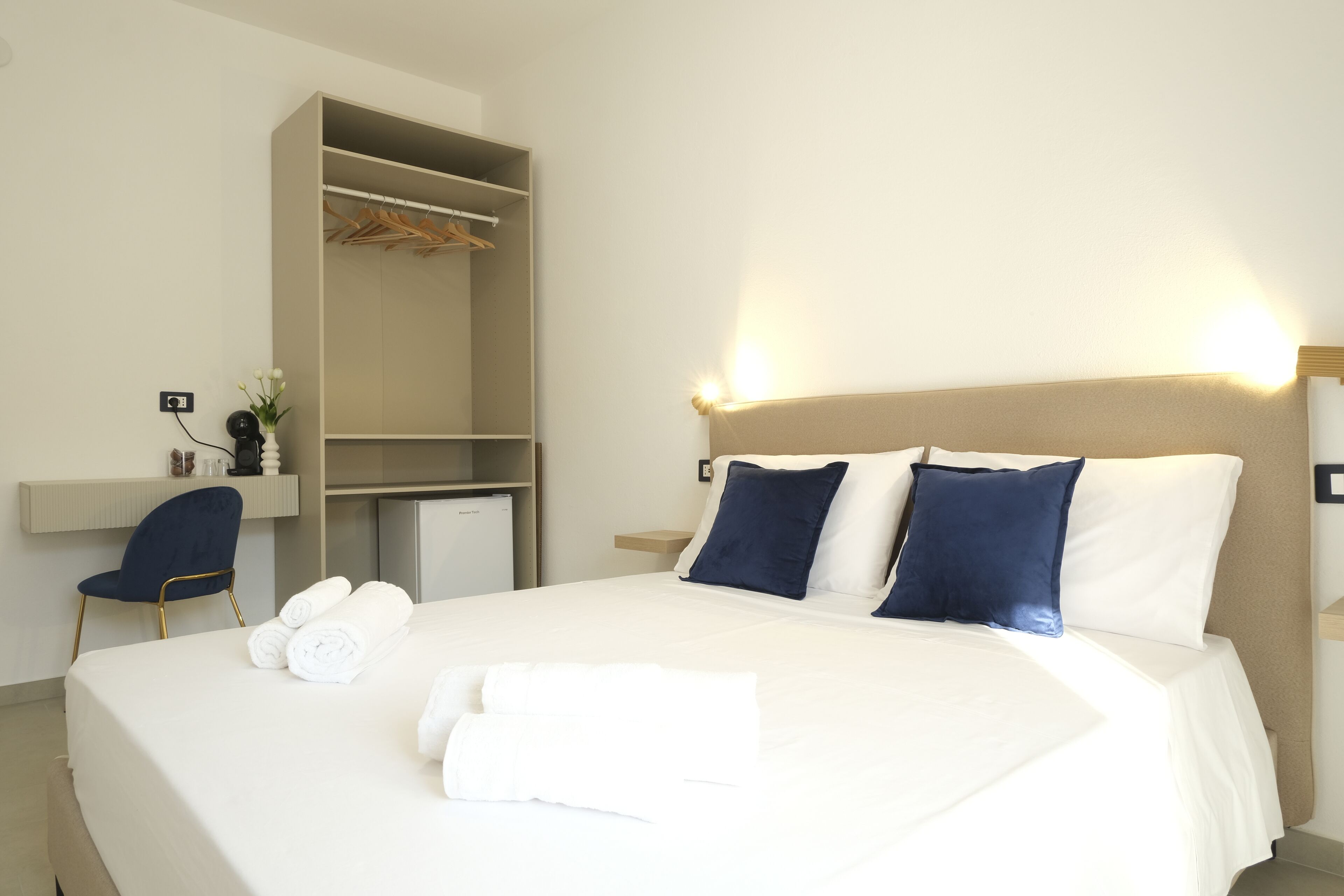 Ein Hotelzimmer mit Bett, Schreibtisch und Kleiderschrank.