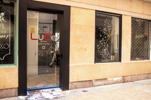 Un immeuble dont la façade comprend une grande vitrine avec l’inscription « LUCE Bilbao Apartments ».
