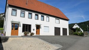 Un bâtiment à deux étages, doté d’un toit recouvert de tuiles rouges, de nombreuses fenêtres et d’une entrée principale.