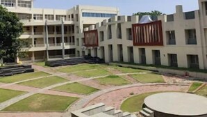A courtyard with a central circular area, surrounded by multi-story buildings with large windows and a flat roof. - Hotel Lakefront (Ranchi)