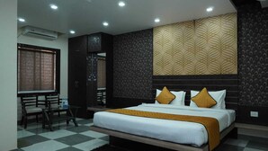 A bedroom with a bed, a desk, and a chair. - Hotel Lakefront (Ranchi)