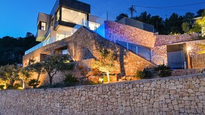 A modern house with a stone facade, large windows, and a balcony. - Villa Bali by Marhen Homes (Javea / Xàbia)