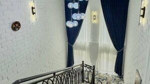 A staircase with a metal railing, white brick walls, and a patterned carpet. - Siab Boutique Hotel (Samarkand)