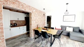 Un espace de vie compact comprenant une cuisine, un coin repas et un coin salon.