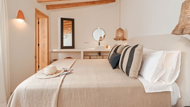 A bedroom with a bed, a bedside table, a mirror, a hanging light fixture, and a wooden ceiling. - Casa Paraiso by Marhen Homes (Javea / Xàbia)