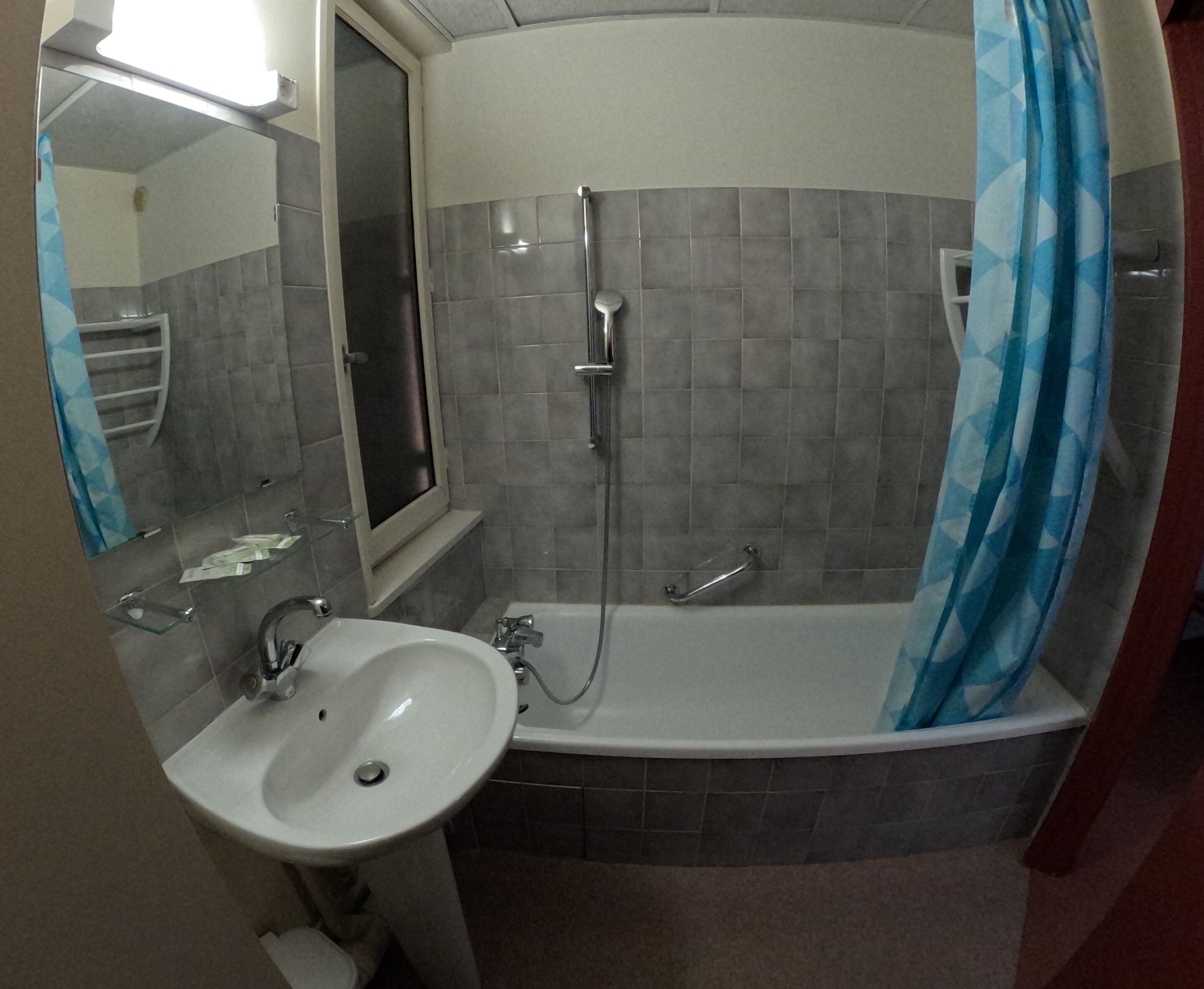 Un baño con lavamanos, espejo, ducha y bañera.