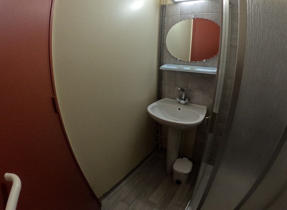 A small bathroom with a white sink, a mirror, and a toilet.