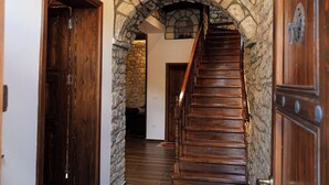 Una escalera de madera con paredes de piedra y un candelabro.