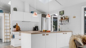 A modern kitchen with white cabinetry, a wooden countertop, and pendant lighting. - "Eilke" - 2km from the sea by Interhome (Ålbæk)