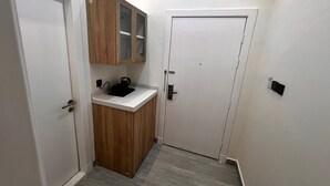 Eine kleine, kompakte Küche mit einem Holzkasten, einer Arbeitsplatte und einer Kaffeemaschine.