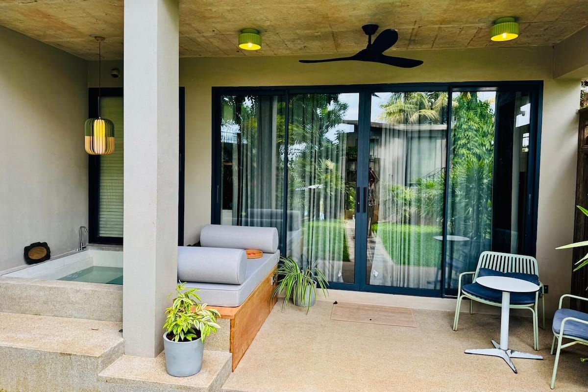Un espace extérieur moderne aménagé avec un canapé, une petite table et une chaise.