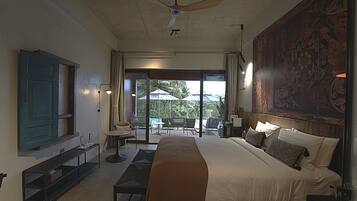 A spacious bedroom with a large bed, a ceiling fan, a TV, and a view of the outdoors.