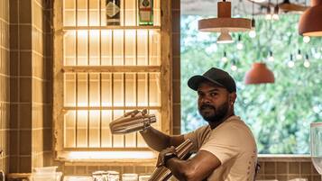 Un área de bar con mostrador, botellas y luces colgantes.