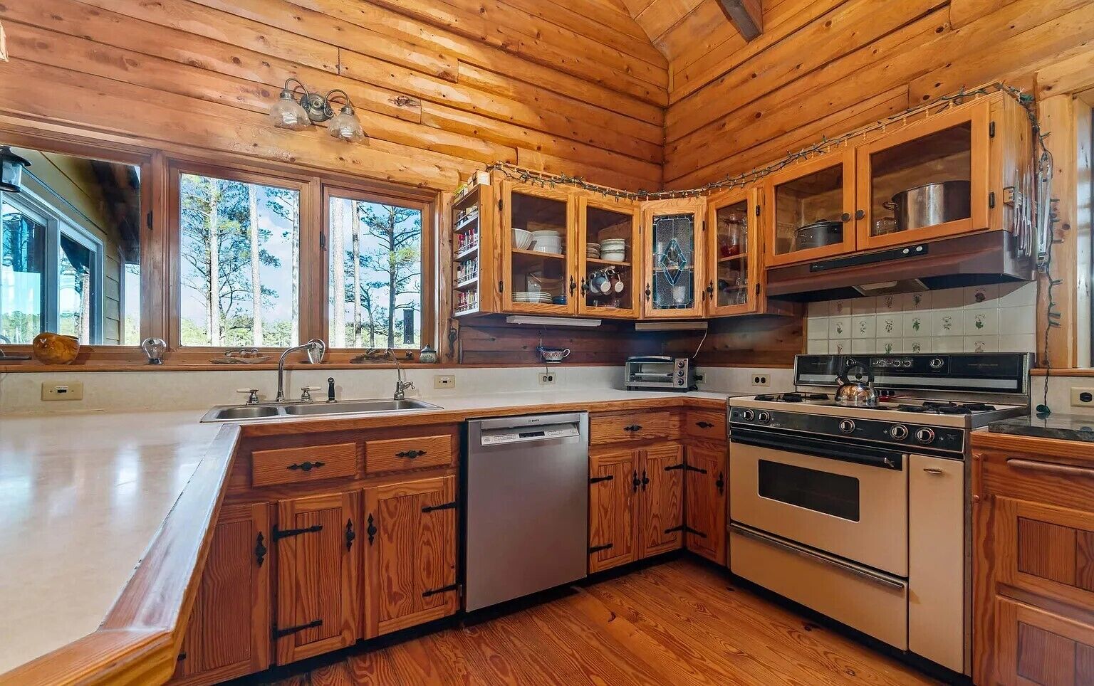Cozinha de cabana rústica com uma ilha grande, armários embutidos e máquina de lavar louça.