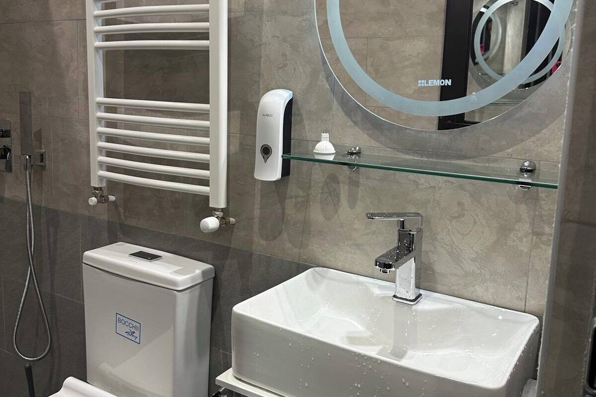 A modern bathroom with a toilet, bidet, and sink.