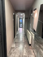 A corridor with a view to a pool, a radiator, and a door marked "POOL".