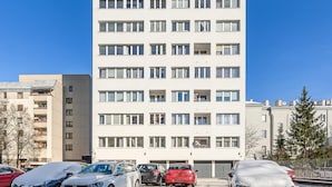 En hög, modern hyresfastighet med flera våningar och många fönster.