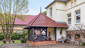 A traditional building with a red-tiled roof, a covered porch, and a sign reading 'Granse.'