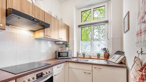 A modern kitchen with a built-in stove, microwave, and oven, wooden cabinets, a window with a view, and a sink with a knife block. - Apartment 2 with Shared Terrace and Wi-Fi (Lindow (Mark))