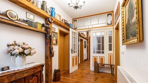 A hallway with wooden flooring, a radiator, a wooden cabinet with a vase of flowers, and a chair. - Apartment 2 with Shared Terrace and Wi-Fi (Lindow (Mark))