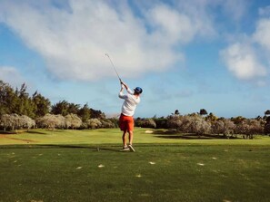 A person playing golf on a well-maintained course with trees and clear skies. - Luxury Stay Near Grand Prix Track (Melbourne)
