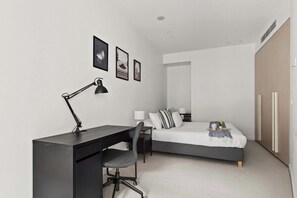 A bedroom with a bed, desk, chair, and bedside tables. - Luxury Stay Near Grand Prix Track (Melbourne)