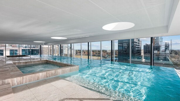 A modern indoor swimming pool with a view of the cityscape. - Luxury Stay Near Grand Prix Track (Melbourne)