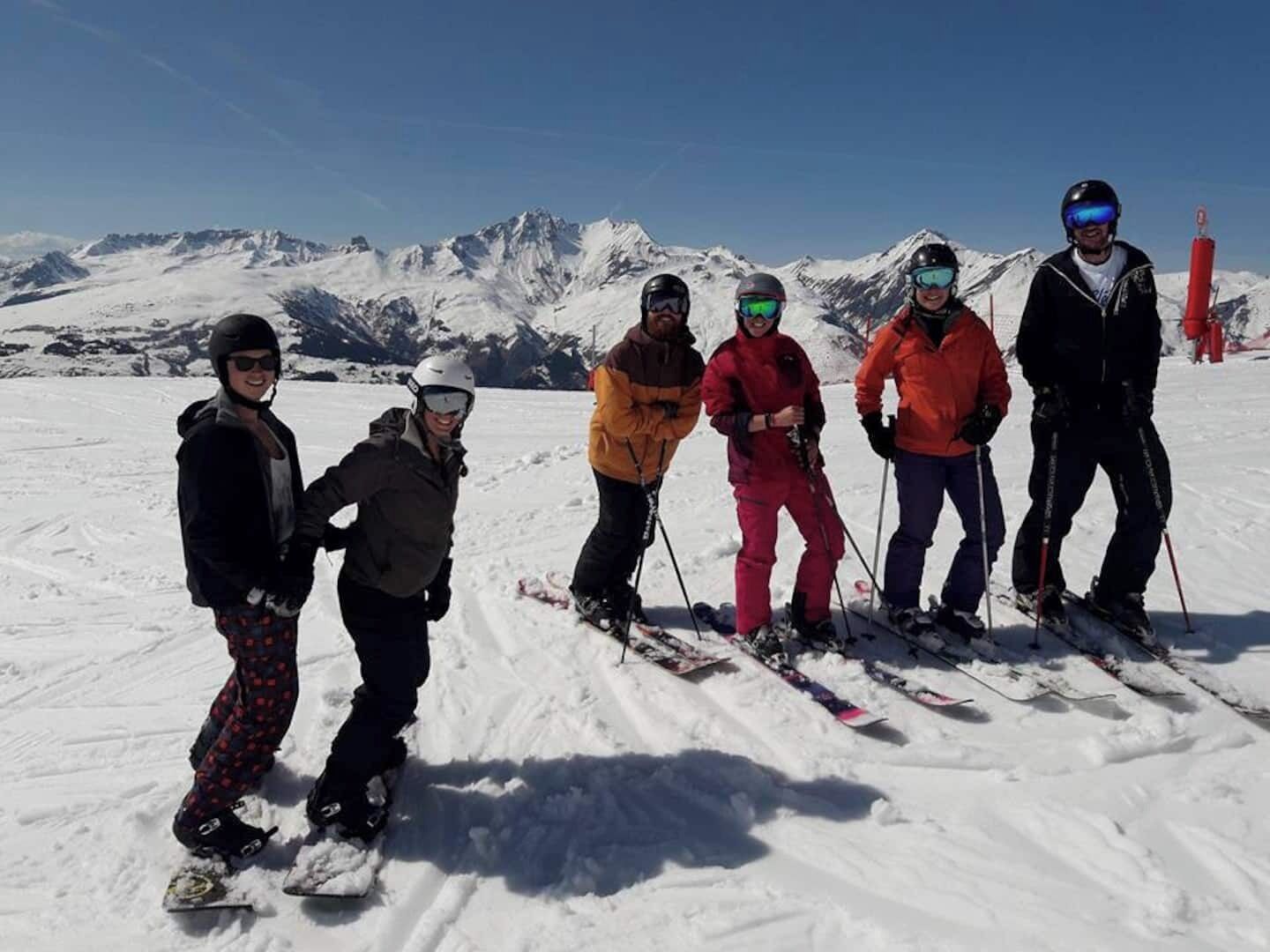 A group of skiers on a snowy mountain with clear skies.