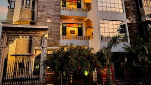 A multi-story building with balconies, a gated entrance, and a sign indicating a hotel. - Hotel Kanak Niwas (Udaipur)