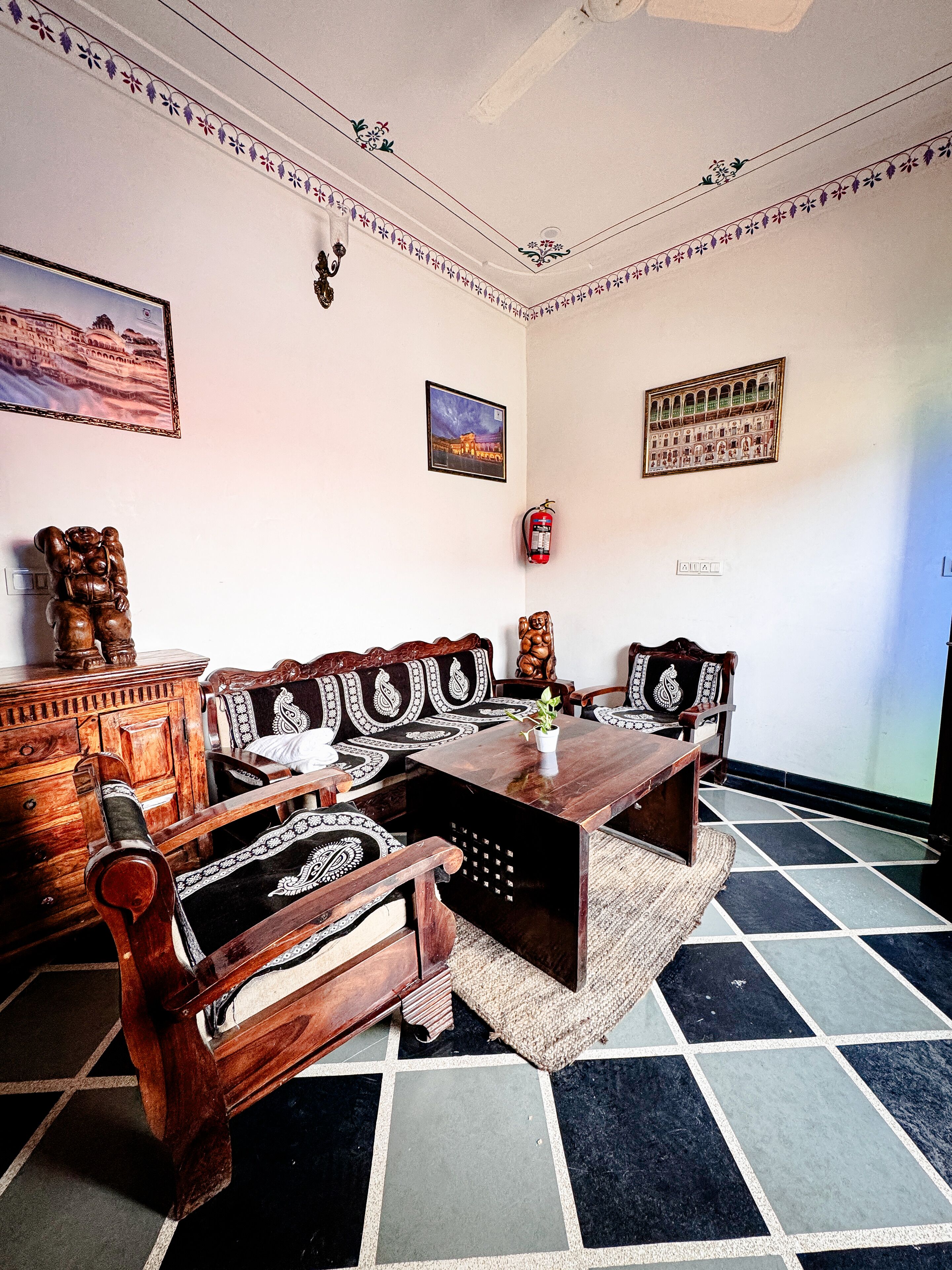 A traditional room with a sofa set, wooden cabinet, and a tiled floor.