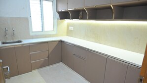 A kitchen with a sink, cabinets, and a window. - Family Ties Homestay (Varanasi)