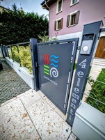 Un cancello con un cartello Bed&B Breakfast, un cancello in metallo e un edificio sullo sfondo.