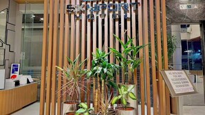 Un área de recepción de diseño moderno, con un muro de listones de madera y un cartel que dice 