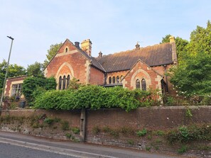 En historisk kirke med facade af mursten, buede vinduer og et tag med teglsten.
