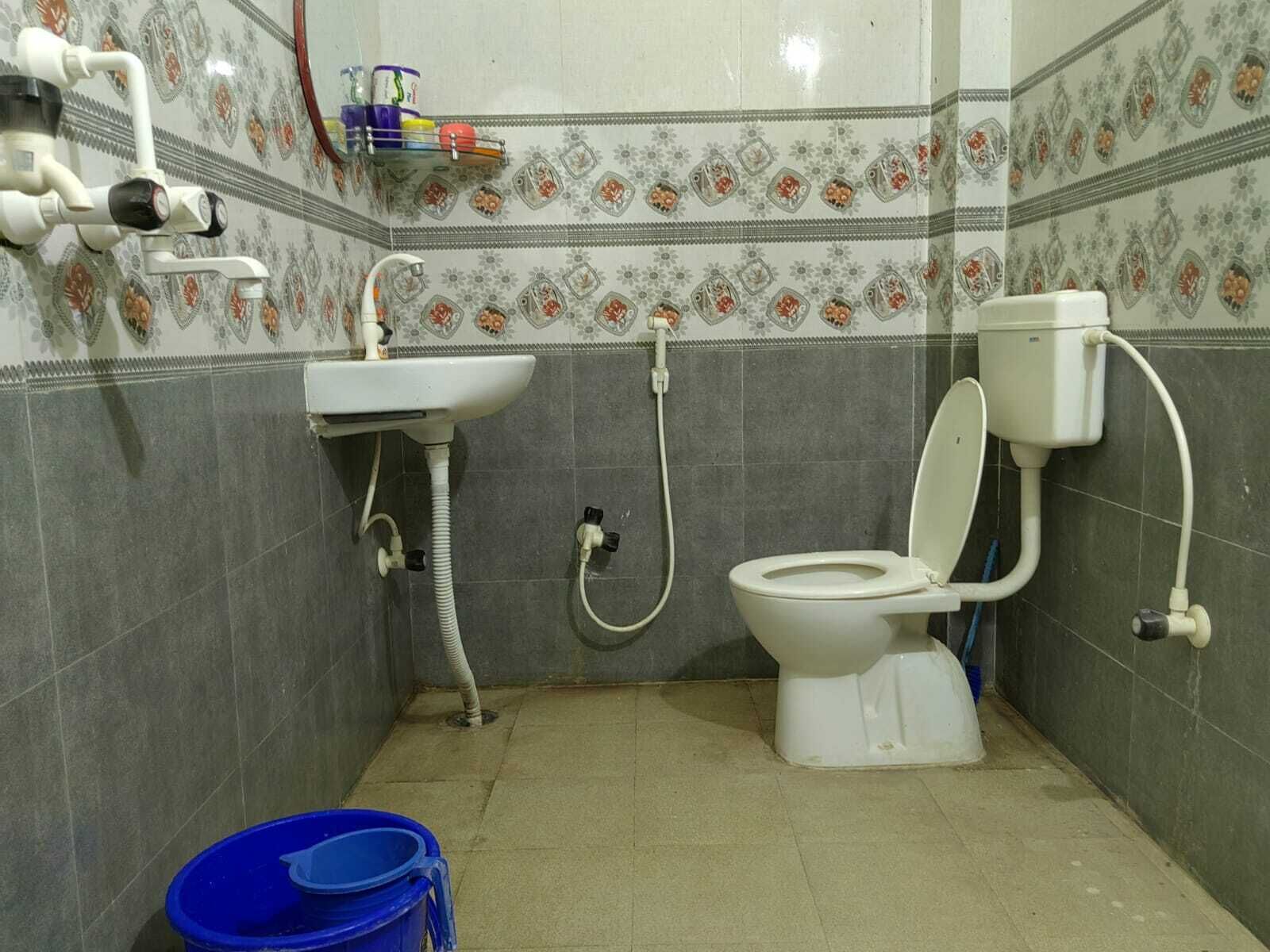 A bathroom with a toilet, sink, and shower.