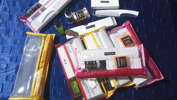 A collection of personal care items, including shaving kits and dental kits, arranged on a blue textured surface. - Eshan Yoga  (Bodh Gaya)