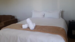 A neatly made bed with white linens, a brown throw blanket, and two rolled towels on the bed. - Bedsitter Bed & Breakfast in Nyanga near popular Attractions (Nyanga)
